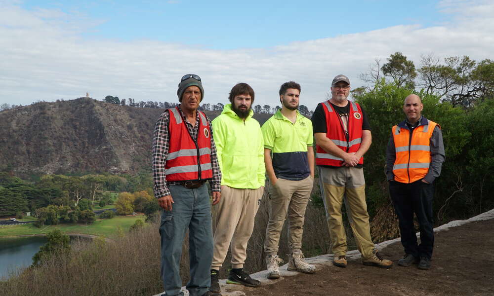 Aboriginal Elder, Southern Ground representative and Director of Burrandies Aboriginal Corporation Uncle Doug Nicholls, Burrandies Aboriginal Corporation labour hire team members Jayden Watson and Emayah Young, Limestone Coast Landscape Board  Engagement Coordinator, First Nations Partnerships David New and City of Mount Gambier Engineering Technical Officer Sinaway Georgiou prepare to revegetate with native plant seedlings around the crater rim thanks to a Landscape SA Grassroots Grant.