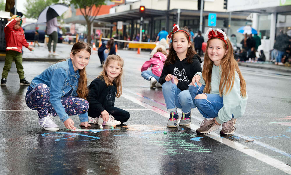 Children and families wait with enthusiasm behind the blue line along Commercial Street for the parade to begin.