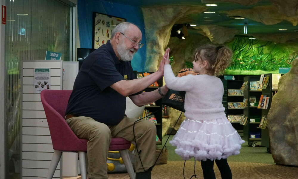 High five: Tigerlilly receives her books from Julian Mattay at the book giving ceremony.