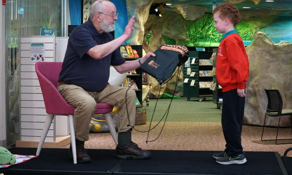 Cooper receives his books from Julian Mattay at the book giving ceremony.