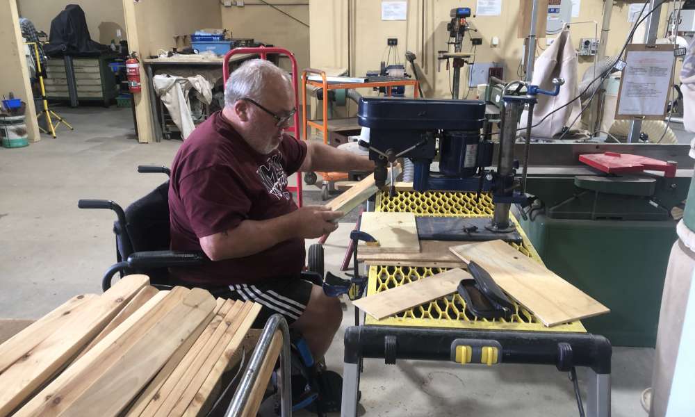 Laurie Tricker drills holes in pickets.