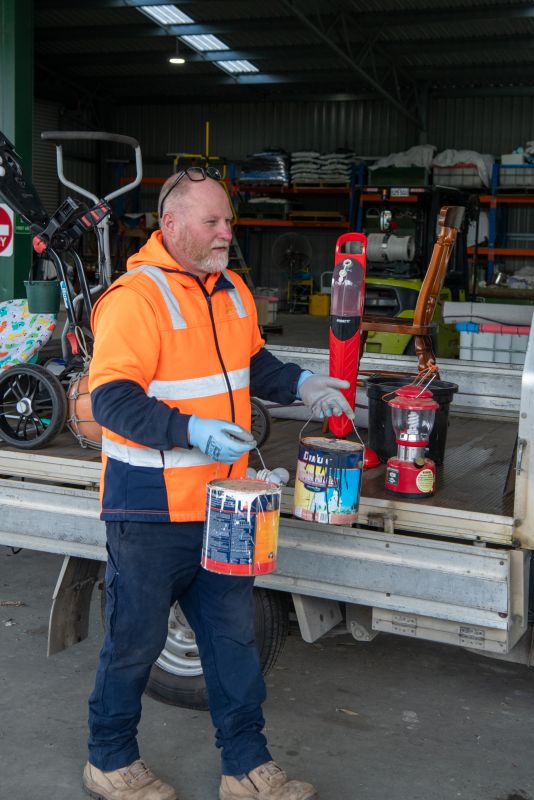 Waste Transfer Station attendant Jamie Hunt with paint for disposal.