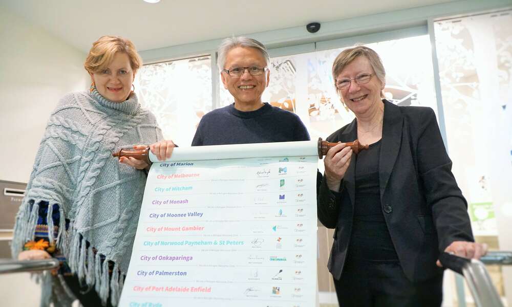 Mayor Andrew Lee is pictured holding the Welcome Scroll with Mount Gambier Migrant Resource Centre Manager Anelia Blackie (left) and Rural Australians for Refugees & Refugee Council of Australia's Jan Govett.