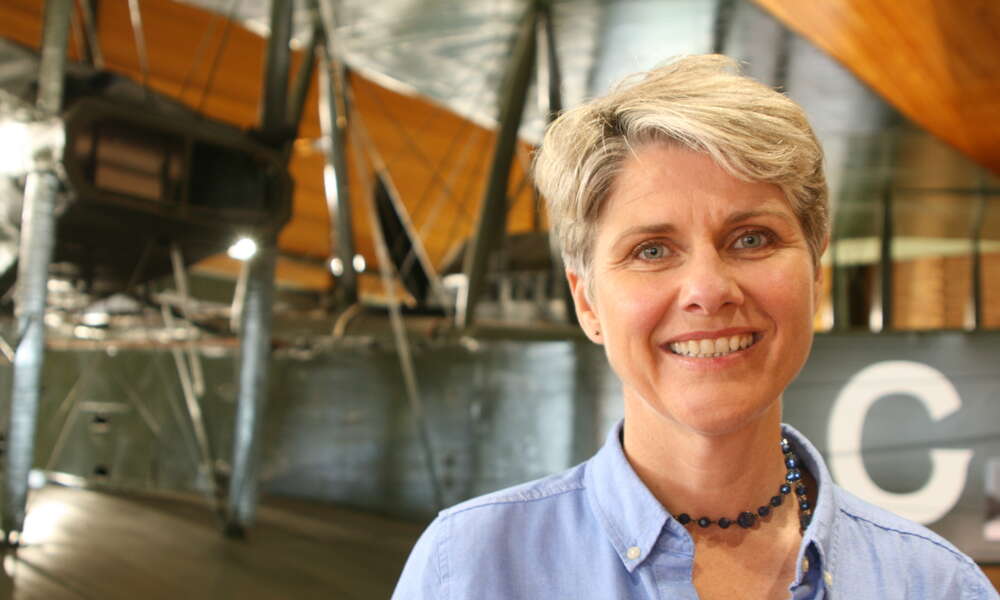 ​Sunday Mail columnist and author Lainie Anderson stands in front of the Vickers Vimy - the same open cockpit biplane that won the 1919 Great Air Race and the feature of her book 'Long Flight Home'.