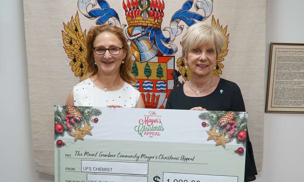Barbara Beal presents Mayor Martin with donation to the Mount Gambier Community Mayor's Christmas Appeal on behalf of UFS Chemist.