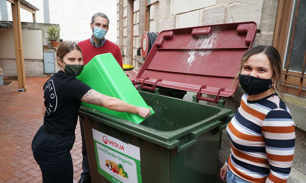 City of Mount Gambier Sustainability Officer Aaron Izzard, Presto Eatery Head Chef Kathryn Holmes and Manager Kate Wilson empty food waste into the skip bin as part of the food waste diversion trial.