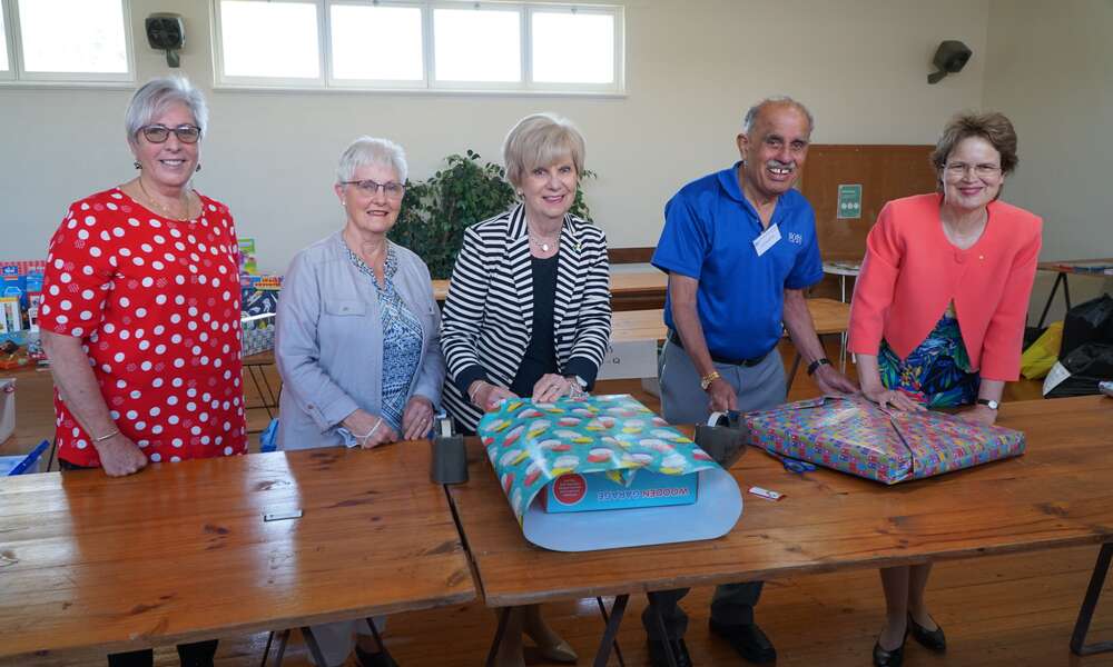 Uniting Care’s Jan Stafford and Laura Kilsby, Mayor Lynette Martin, St Vincent de Paul’s John d’Souza and Her Excellency the Honourable Frances Adamson AC wrap gifts at the Uniting Church.