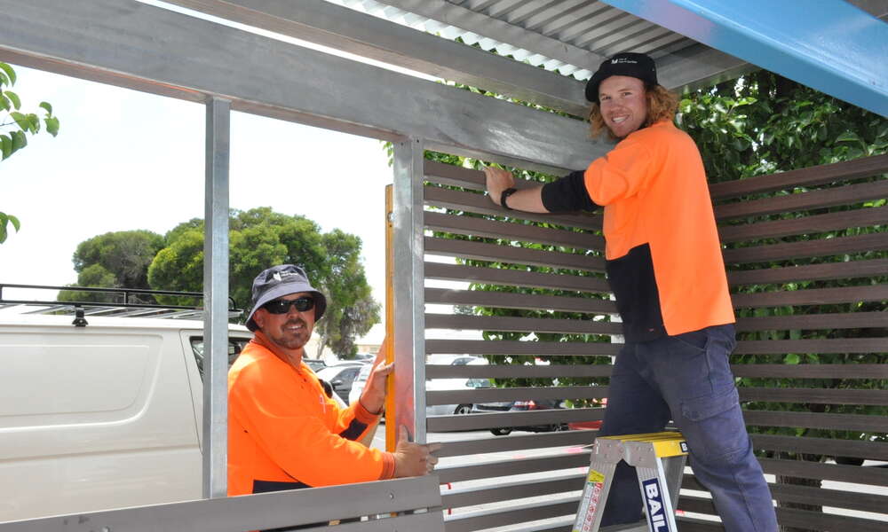 City of Mount Gambier outdoor staff Shaun Horrigan and Sam Egan erect one on the bus shelters on James Street Mount Gambier.